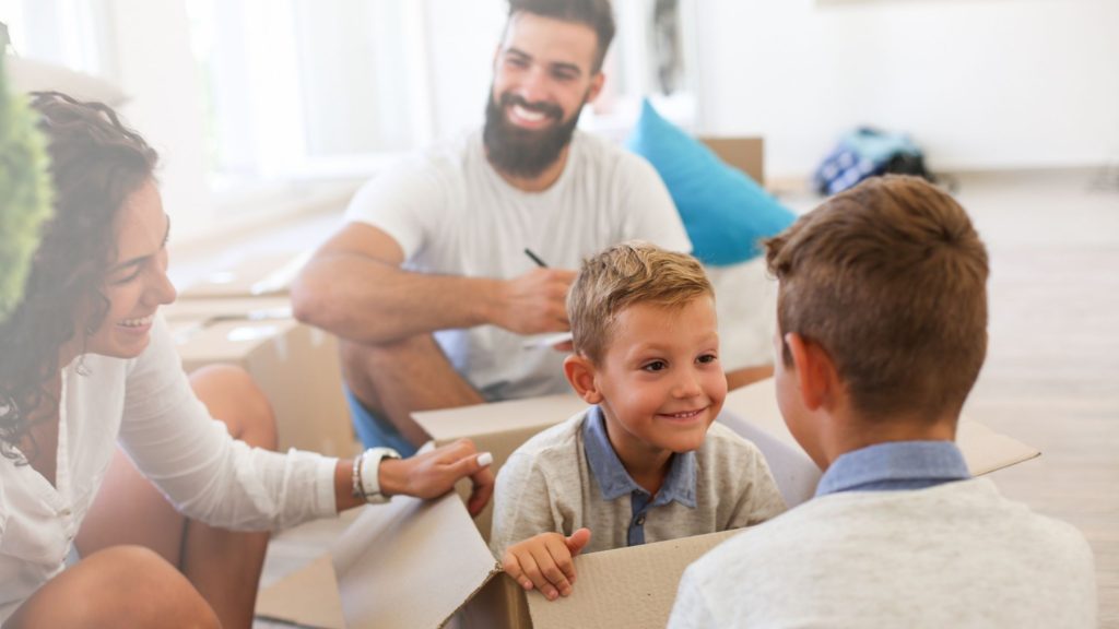 Família feliz, casal com dois filhos, o menor dentro de uma caixa. Representando as muitas mudanças que estão acontecendo no período!